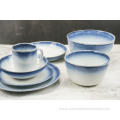 Reactive glazed stoneware dinner set with blue rim